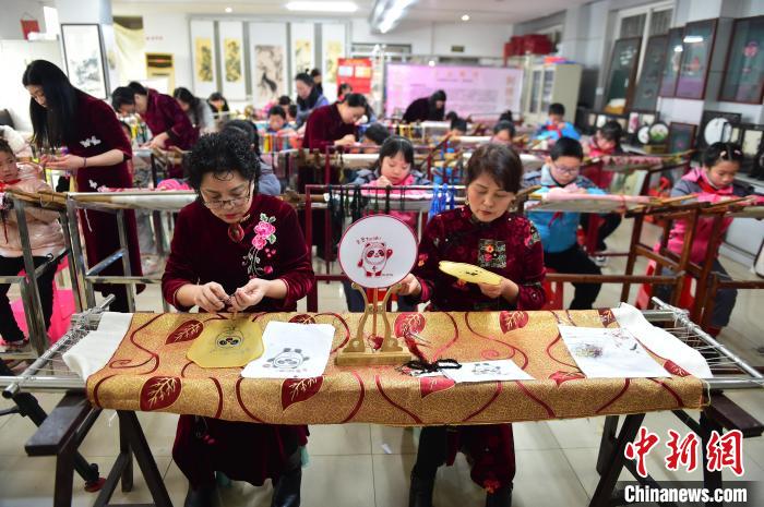 江西省級(jí)非遺豫章繡傳承人手把手指導(dǎo)小學(xué)生繡制2022年北京冬奧會(huì)吉祥物“冰墩墩”形象?！∮髟屏?攝