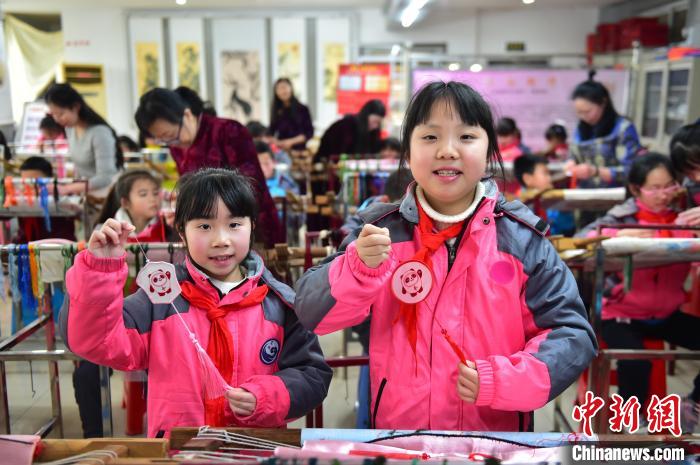 圖為小學(xué)生展示繡制好的2022年北京冬奧會(huì)吉祥物“冰墩墩”形象?！∮髟屏?攝