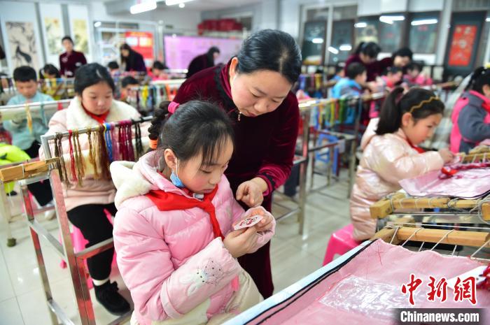江西省級(jí)非遺豫章繡傳承人手把手指導(dǎo)小學(xué)生繡制2022年北京冬奧會(huì)吉祥物“冰墩墩”形象?！∮髟屏?攝