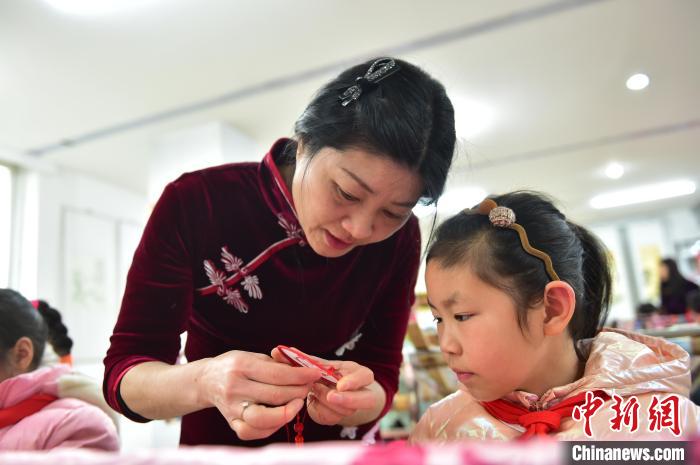江西省級(jí)非遺豫章繡傳承人手把手指導(dǎo)小學(xué)生繡制2022年北京冬奧會(huì)吉祥物“冰墩墩”形象?！∮髟屏?攝
