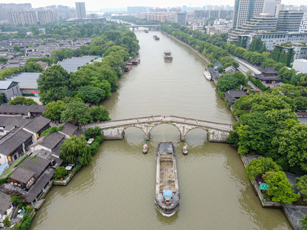 5月27日，一艘貨船駛過京杭大運河南端標志建筑杭州拱宸橋。(無人機照片)新華社記者江漢 攝