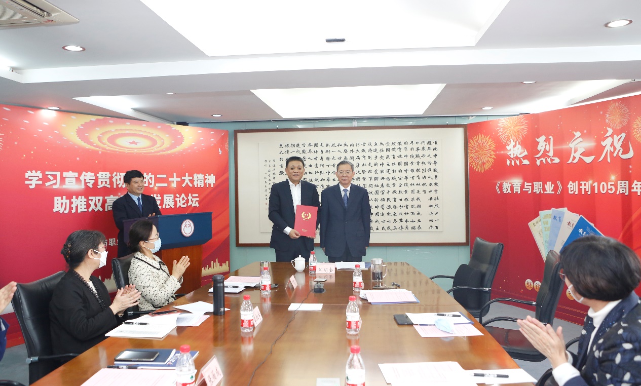 郝明金為《教育與職業(yè)》雜志編委代表陳曉明頒發(fā)聘書。中華職教社供圖