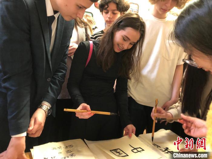 4月21日，莫斯科國立語言大學(xué)孔子學(xué)院附屬中學(xué)舉辦“國際中文日”活動(dòng)，學(xué)生們學(xué)寫漢字?！∧箍茋⒄Z言大學(xué)孔子學(xué)院 供圖