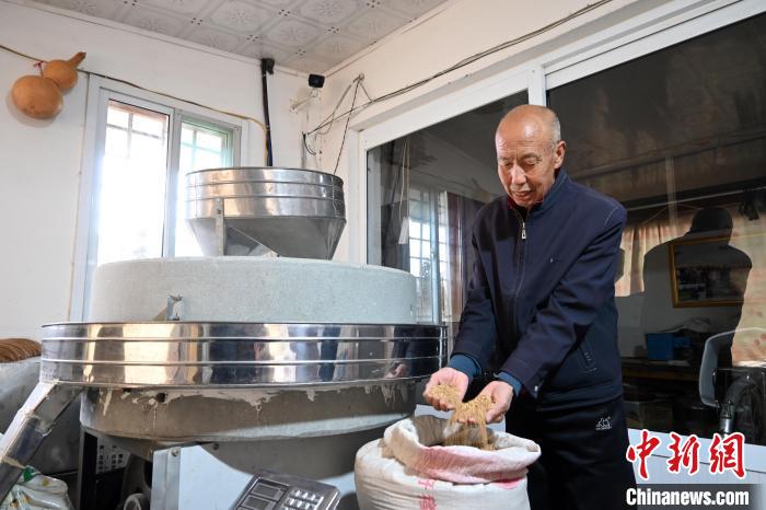 李家莊村民谷文朝重拾父輩的手藝，做起石磨面粉的營生?！〉杂鸺?攝