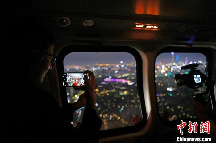 6月3日晚，游客乘坐上海新空直升機(jī)有限公司直升機(jī)開啟鳥瞰黃浦江空中圓夢(mèng)之旅，并用手機(jī)拍攝城市夜景。　殷立勤 攝