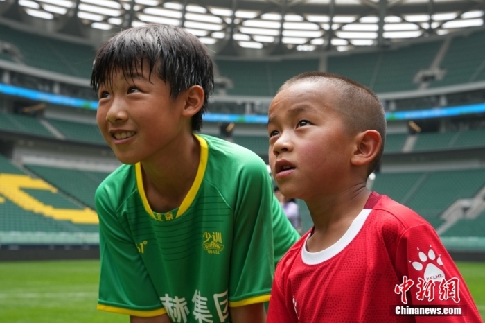 圖為北京國(guó)安小球員陳小北和7歲的俄金仁增在一起觀看場(chǎng)內(nèi)播放的紀(jì)錄片。<a target='_blank' href='/' _fcksavedurl='/'><p  align=