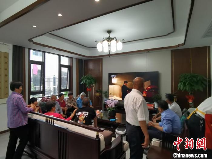 親友們集中在費(fèi)俊龍家中觀看返程的視頻?！＄娚?攝