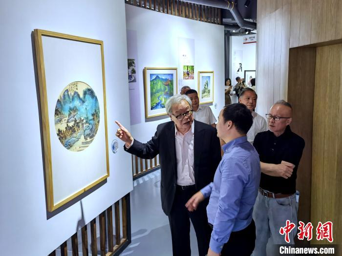 海峽兩岸藝術(shù)家畫展上，藝術(shù)家進(jìn)行藝術(shù)交流?！「毒窜?攝