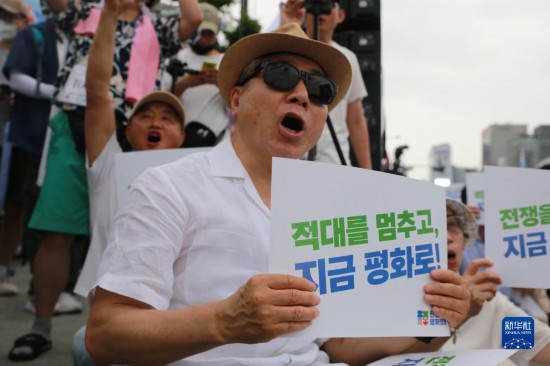 7月22日，在韓國首爾，人們手舉標語參與反戰(zhàn)游行。新華社發(fā)（楊暢 攝）