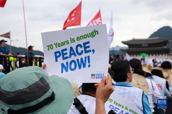 7月22日，在韓國首爾，人們手舉標語參與反戰(zhàn)游行。新華社發(fā)（楊暢 攝）