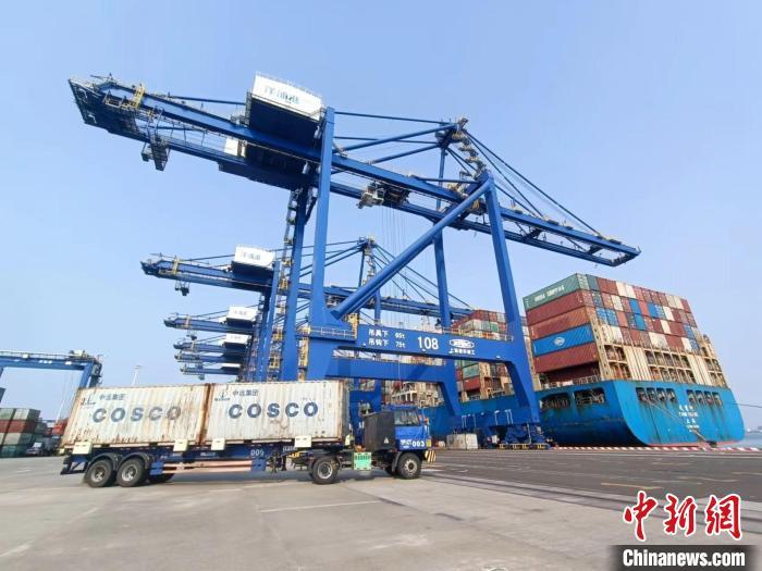 圖為海南洋浦國際集裝箱碼頭，卡車將集裝箱從后方堆場運往碼頭裝卸區(qū)?！堅潞?攝
