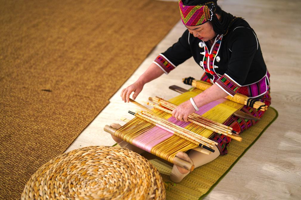 4月17日，黎族傳統(tǒng)紡染織繡技藝國(guó)家級(jí)代表性傳承人劉香蘭在2023年意大利米蘭設(shè)計(jì)周上展示黎錦織造技藝。新華社發(fā)