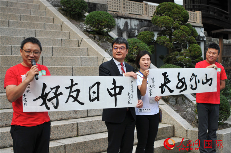 東京中國文化中心主任羅玉泉展示其為本次活動書寫的題詞“中日友好，山高水長”。人民網(wǎng) 蔣曉辰攝