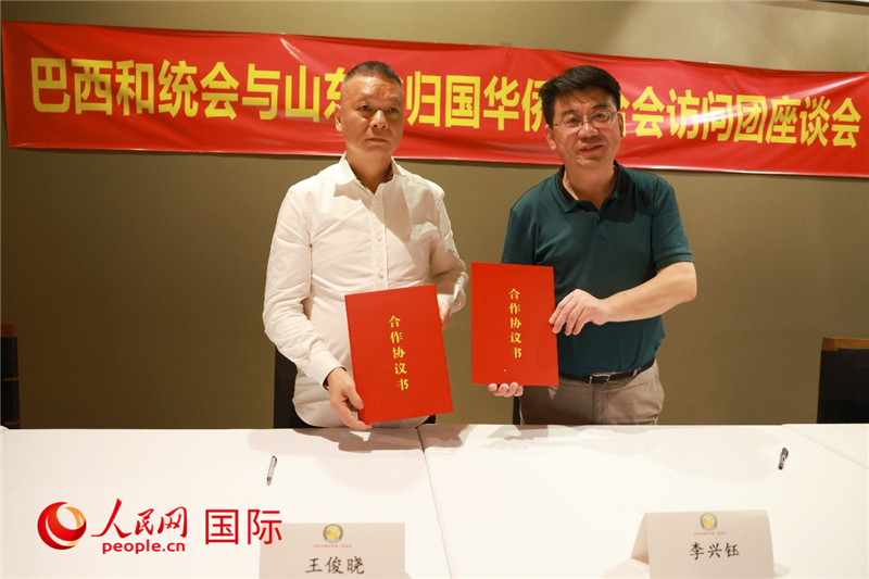中國僑聯(lián)副主席、山東省僑聯(lián)主席李興鈺（右）與巴西和統(tǒng)會(huì)會(huì)長王俊曉簽署合作協(xié)議書。人民網(wǎng)記者 陳海琪攝