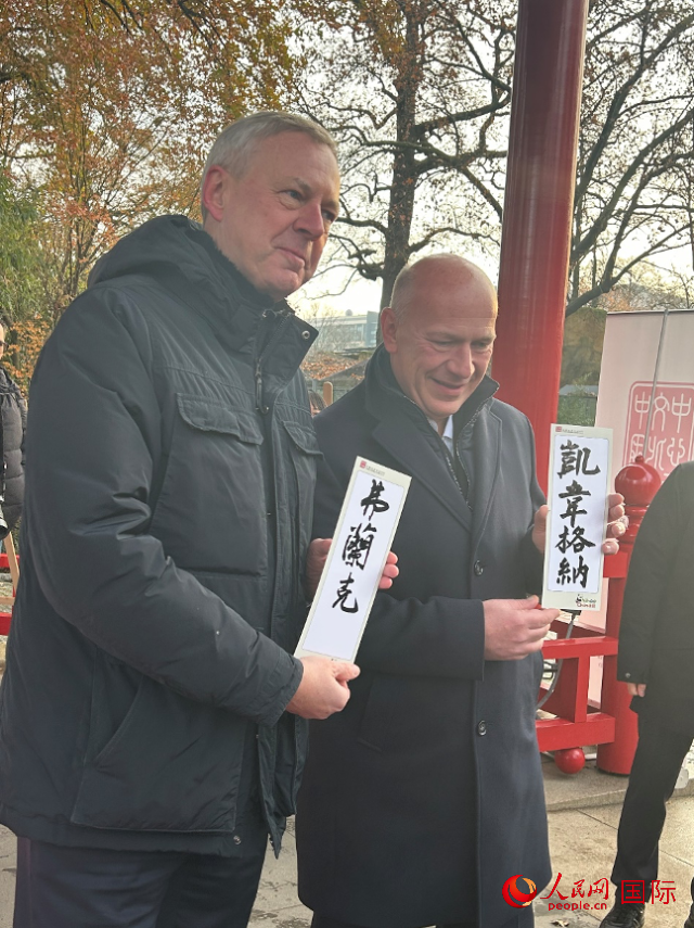 柏林市長(zhǎng)韋格納（右）、動(dòng)物園監(jiān)事會(huì)主席布魯克曼（左）手持中國(guó)文化中心工作人員現(xiàn)場(chǎng)手書(shū)的中文名字。人民網(wǎng)記者 徐馨攝