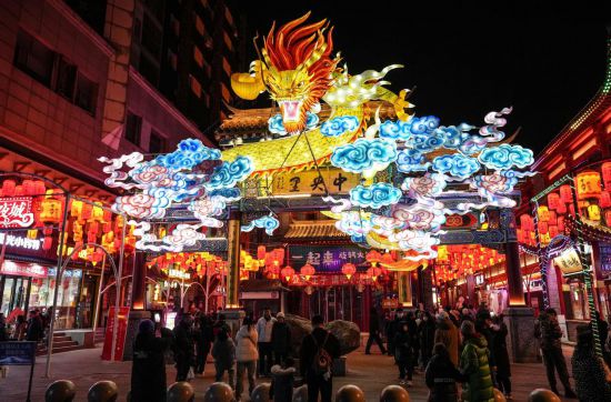 2月11日，游客在沈陽中街游覽。春節(jié)期間，各地?zé)艋痂病⒒饦溷y花，呈現(xiàn)出一幕幕流光溢彩的視覺盛宴。（新華社記者潘昱龍攝）