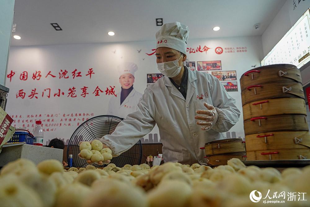 3月31日，在浙江省嵊州市甘霖鎮(zhèn)，嵊州小吃從業(yè)者沈紅平把蒸熟的小籠包晾涼，打包冷藏售賣(mài)。人民網(wǎng) 章勇濤攝