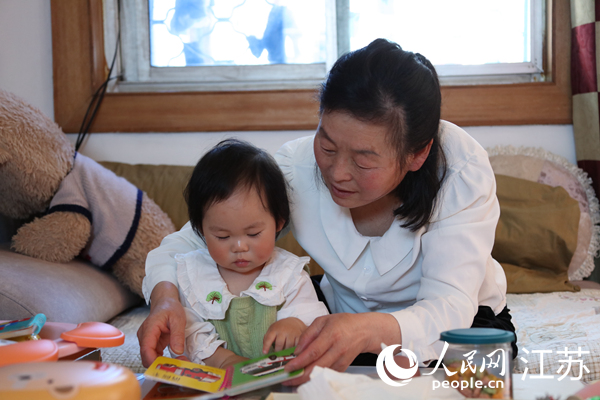 王繼蓮帶孫女看童書(shū)。人民網(wǎng) 冷金明攝