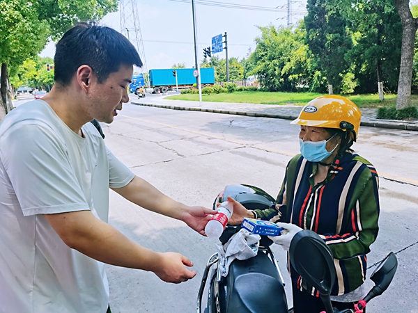 何超為過路的老人送上礦泉水和冷飲。人民網(wǎng)記者 王繼亮攝
