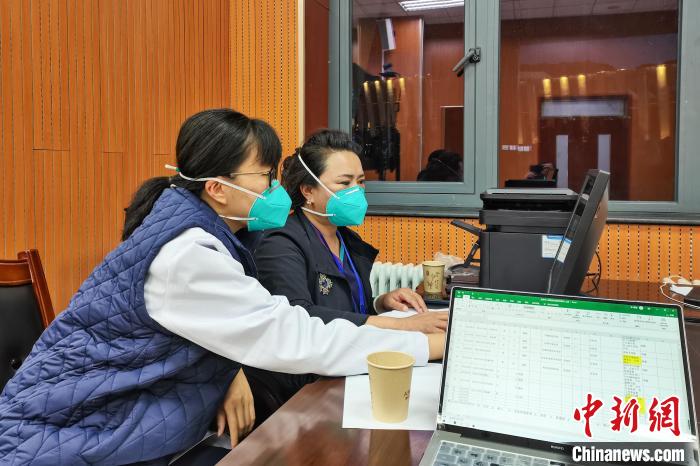 8月9日，楊蘇喬(左)在拉薩方艙醫(yī)院指揮部讀取艙內(nèi)患者胸部CT?！∈茉L者供圖