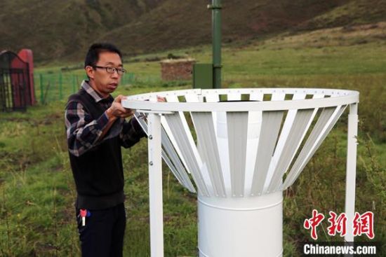 圖為班瑪縣氣象局工作人員在維護藏雪茶基地氣候站。青海省氣象局供圖
