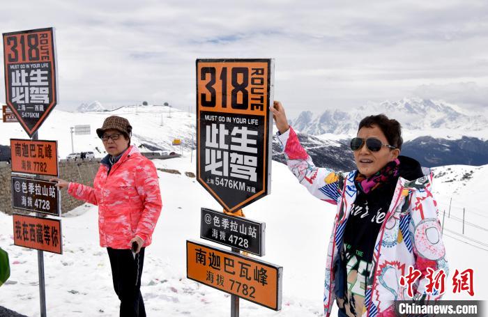 圖為5月14日，西藏林芝色季拉山觀景臺(tái)，游客與南迦巴瓦峰合影?！±盍?攝