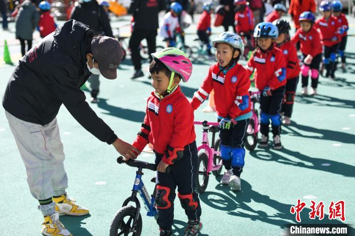 圖為拉薩市實驗幼兒園孩子們在教練的指導(dǎo)下練習(xí)滑步車?！『闻罾?攝