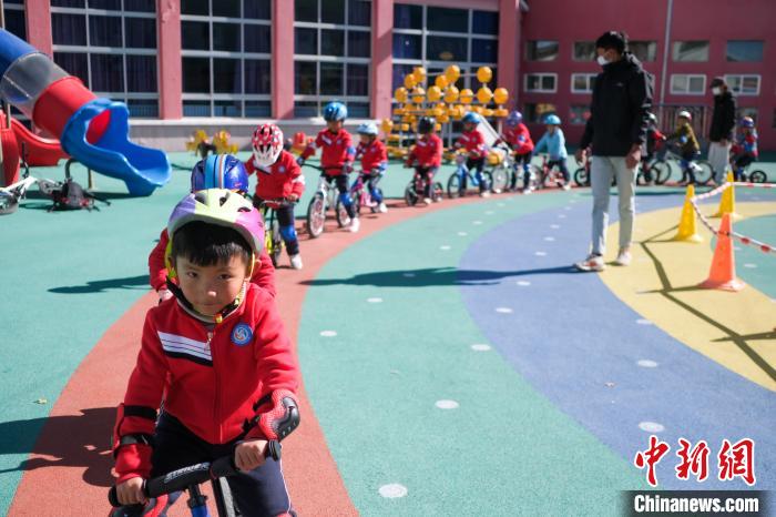 圖為拉薩市實驗幼兒園孩子們在教練的指導(dǎo)下練習(xí)滑步車。　何蓬磊 攝