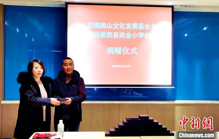 圖為西藏高山文化發(fā)展基金會理事長溫麗向聶榮縣完全小學(xué)負(fù)責(zé)人捐助儀器?！∮谫e 攝