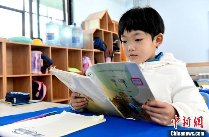 3月14日，西藏拉薩市第一小學(xué)一年級(jí)六班學(xué)生丁增樂(lè)吉在閱讀藏語(yǔ)課本?！±盍?攝
