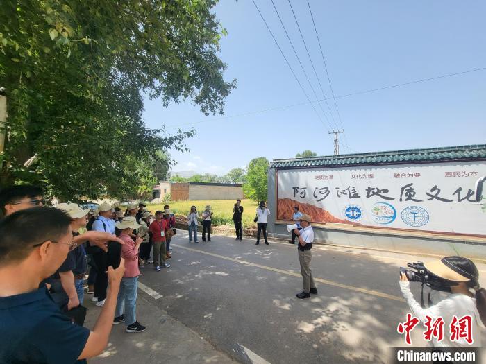 圖為中國地質(zhì)大學(xué)(北京)教授張緒教介紹村落情況?！『衍?攝