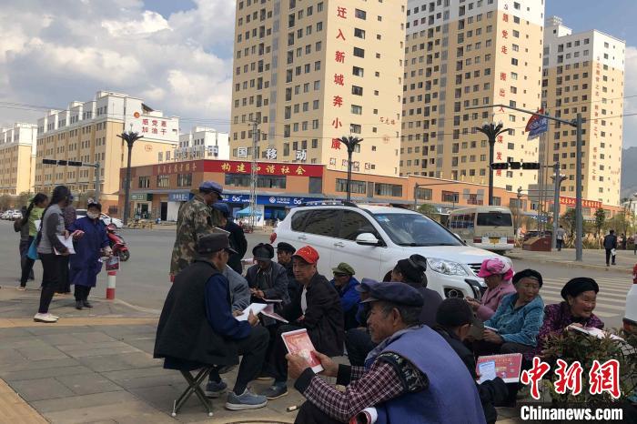 圖為會(huì)澤縣城易地扶貧搬遷安置點(diǎn)內(nèi)，老人們聚在廣場(chǎng)上聊天，身后是他們的新家?！】姵?攝