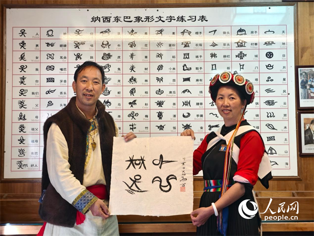 人民網(wǎng)“行進(jìn)中國(guó)”云南調(diào)研采訪團(tuán)走進(jìn)麗江，和閏元現(xiàn)場(chǎng)用東巴文寫(xiě)下“行進(jìn)中國(guó)”。人民網(wǎng)記者 符皓攝
