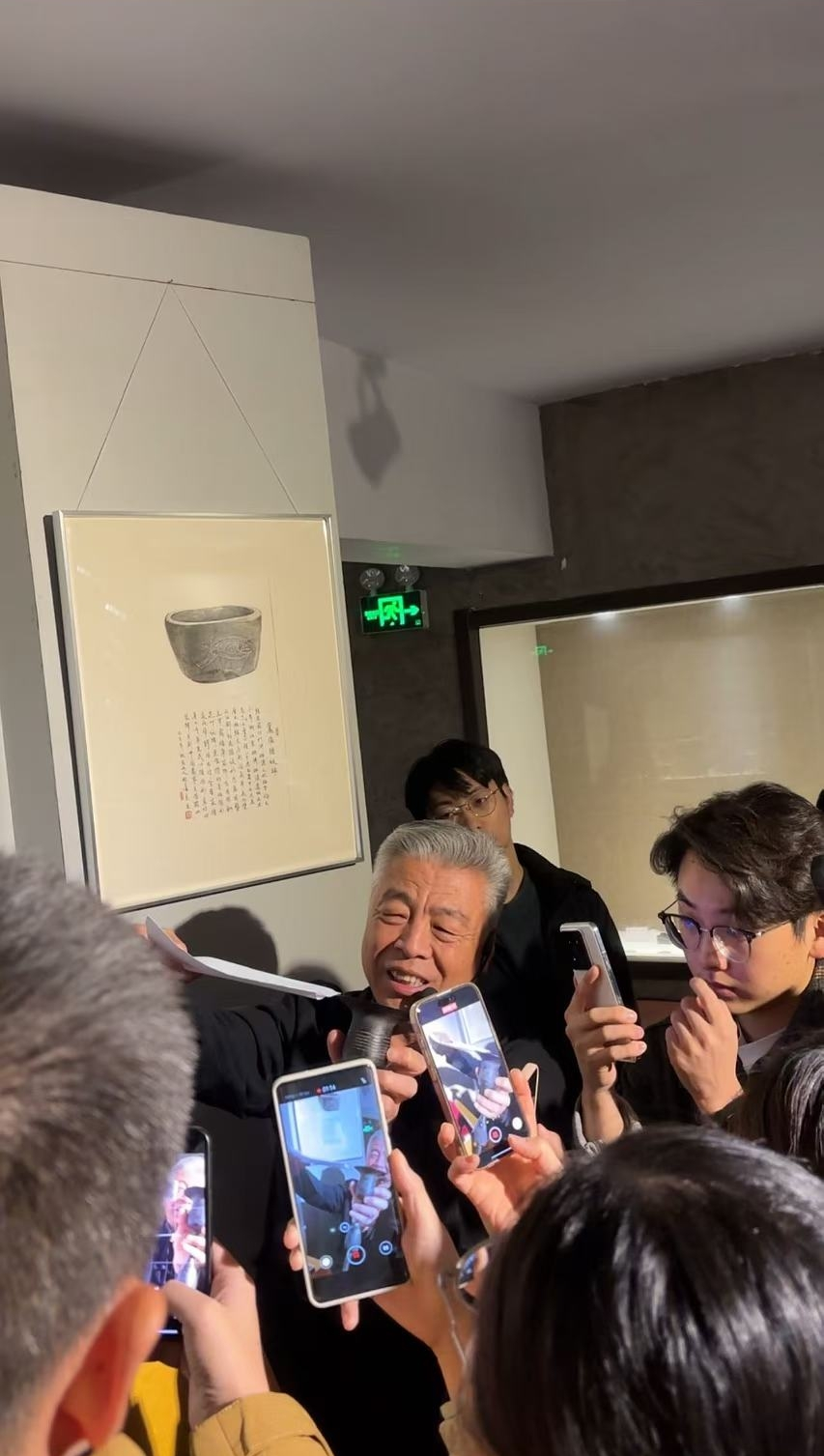 黑陶邢文化博物館館長邢葆東展示兩張相疊的A4紙，向記者解釋此為杯口的厚度。