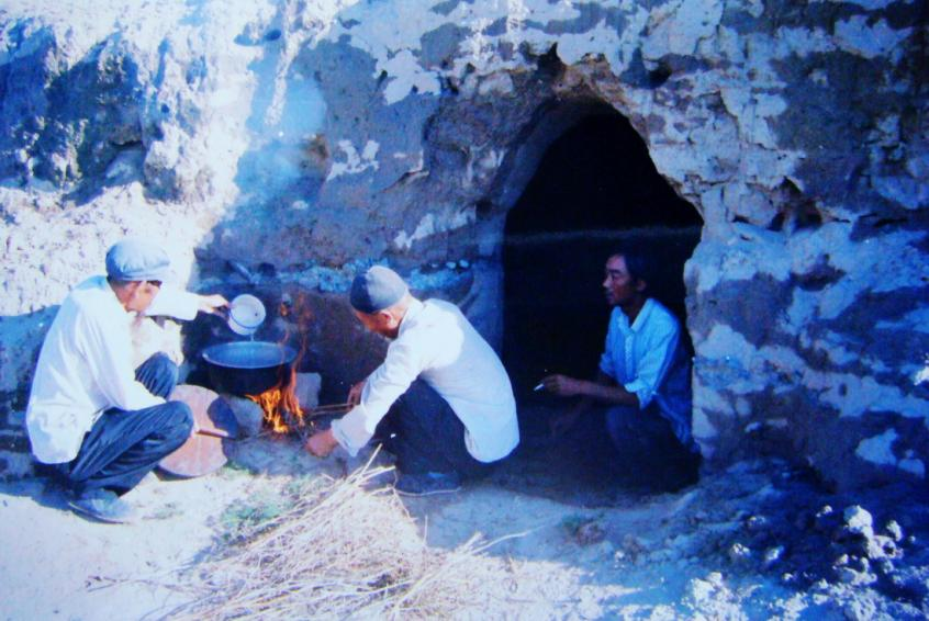 1983年，“六老漢”一代治沙人在“地窩子”生活做飯。新華社發(fā)（八步沙林場供圖）