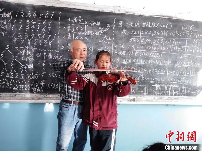 圖為趙興洲教學生拉小提琴。受訪者提供