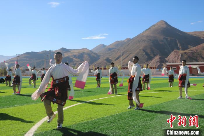 圖為青海師范大學(xué)附屬玉樹實(shí)驗(yàn)學(xué)校學(xué)生在綠茵場(chǎng)跳起囊謙古舞—卓根瑪。　程雨 攝