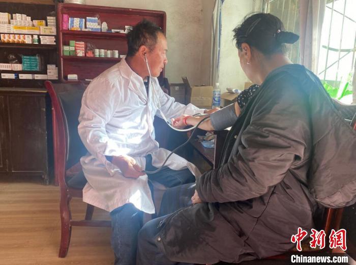 索木滾(左)為村民看病?！∪捞量h委宣傳部供圖