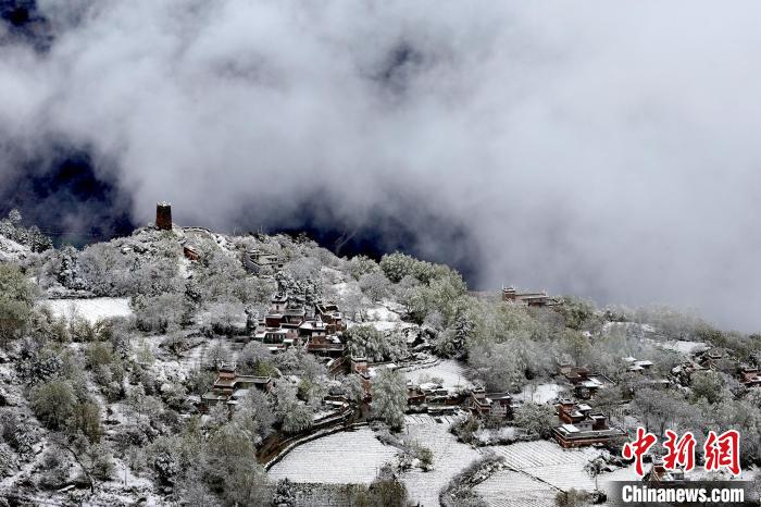 雪后的藏寨和碉樓構(gòu)成美麗的雪景?！〗党鯘衫?攝