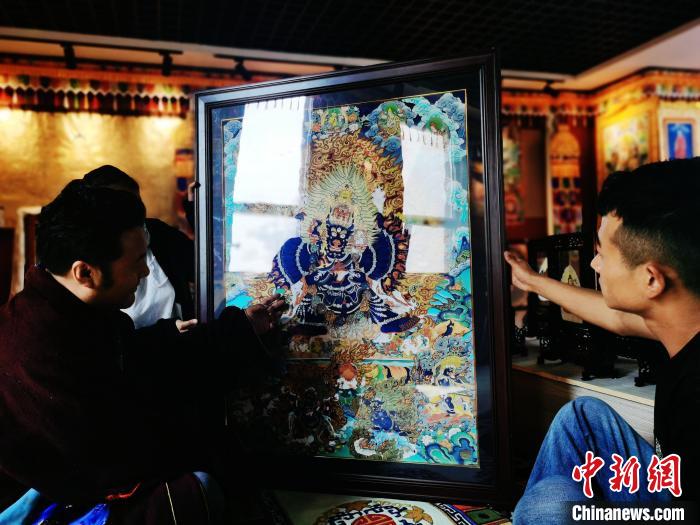 圖為久美尖措(左)與徒弟們展示唐卡作品。　張?zhí)砀?攝