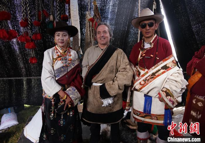圖為一名外籍攝影師(中)身穿藏服和藏族民眾合影留念?！●R銘言 攝
