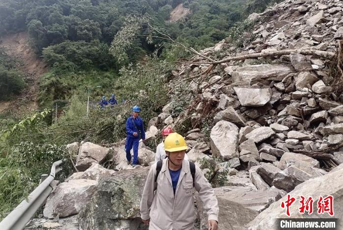 電力搶險(xiǎn)人員徒步通過(guò)垮塌路段。　四川電力供圖