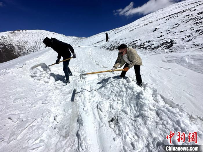 圖為生態(tài)管護人員在巡護道路上清雪。　丁巴達杰 攝