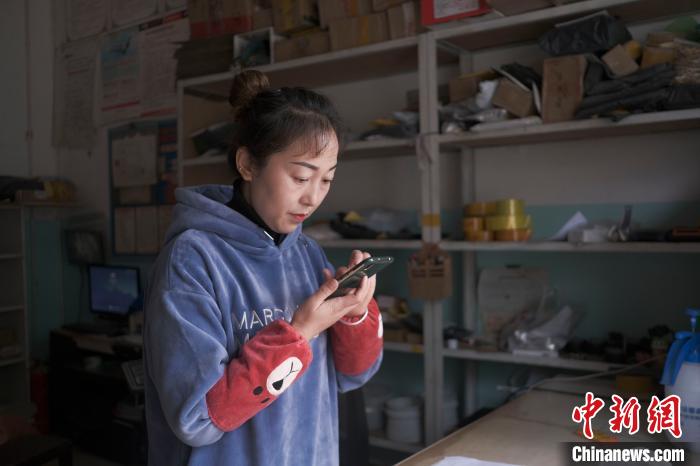 正在快遞站點內(nèi)忙碌的楊莉春。　何蓬磊 攝