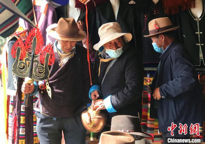 圖為三位藏族老人在集市上聊天交談?！∪轿木?攝