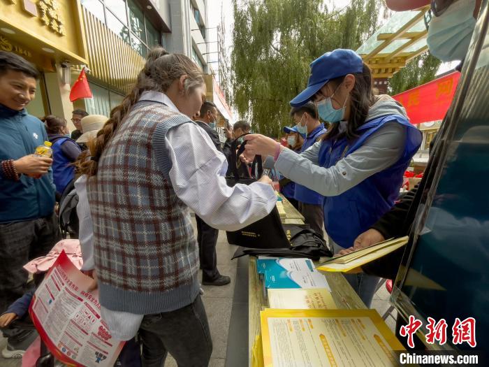圖為志愿者為市民發(fā)放網(wǎng)絡(luò)安全宣傳手冊(cè)?！≈x牧 攝