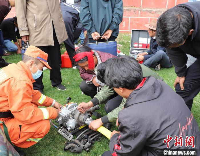 圖為森林消防員為護(hù)林員講解滅火裝備的使用方法。　昌都市森林消防支隊(duì) 供圖