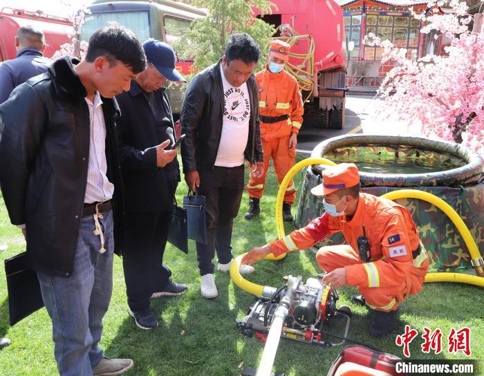 圖為森林消防員為護(hù)林員講解滅火裝備的使用方法?！〔际猩窒乐ш?duì) 供圖