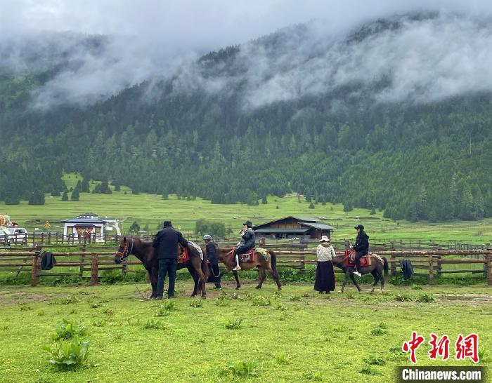 6月10日，游客在魯朗小鎮(zhèn)高山牧場(chǎng)景區(qū)體驗(yàn)騎馬?！∪轿木?攝