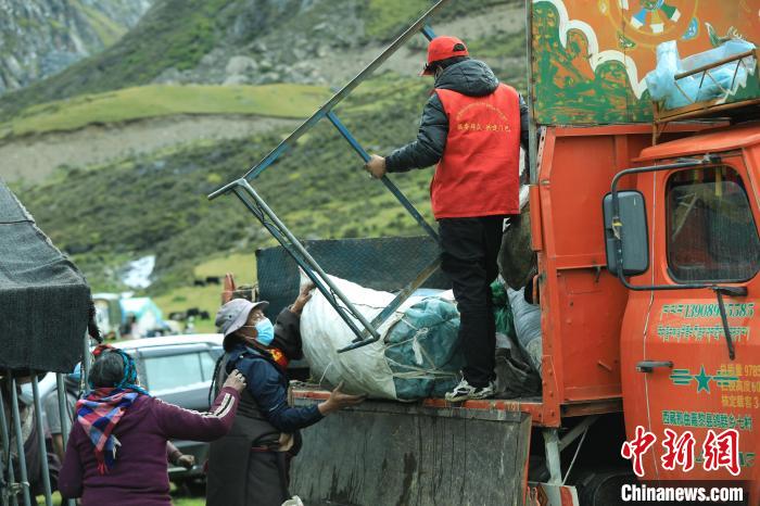 圖為工作人員幫助牧民們卸家具?！÷蹇?攝